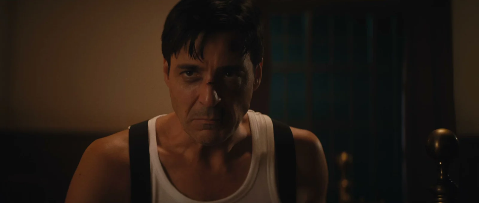 Original Familiar frame: warm key light falls on the camera-left side of a man's face, with the other side in shadow