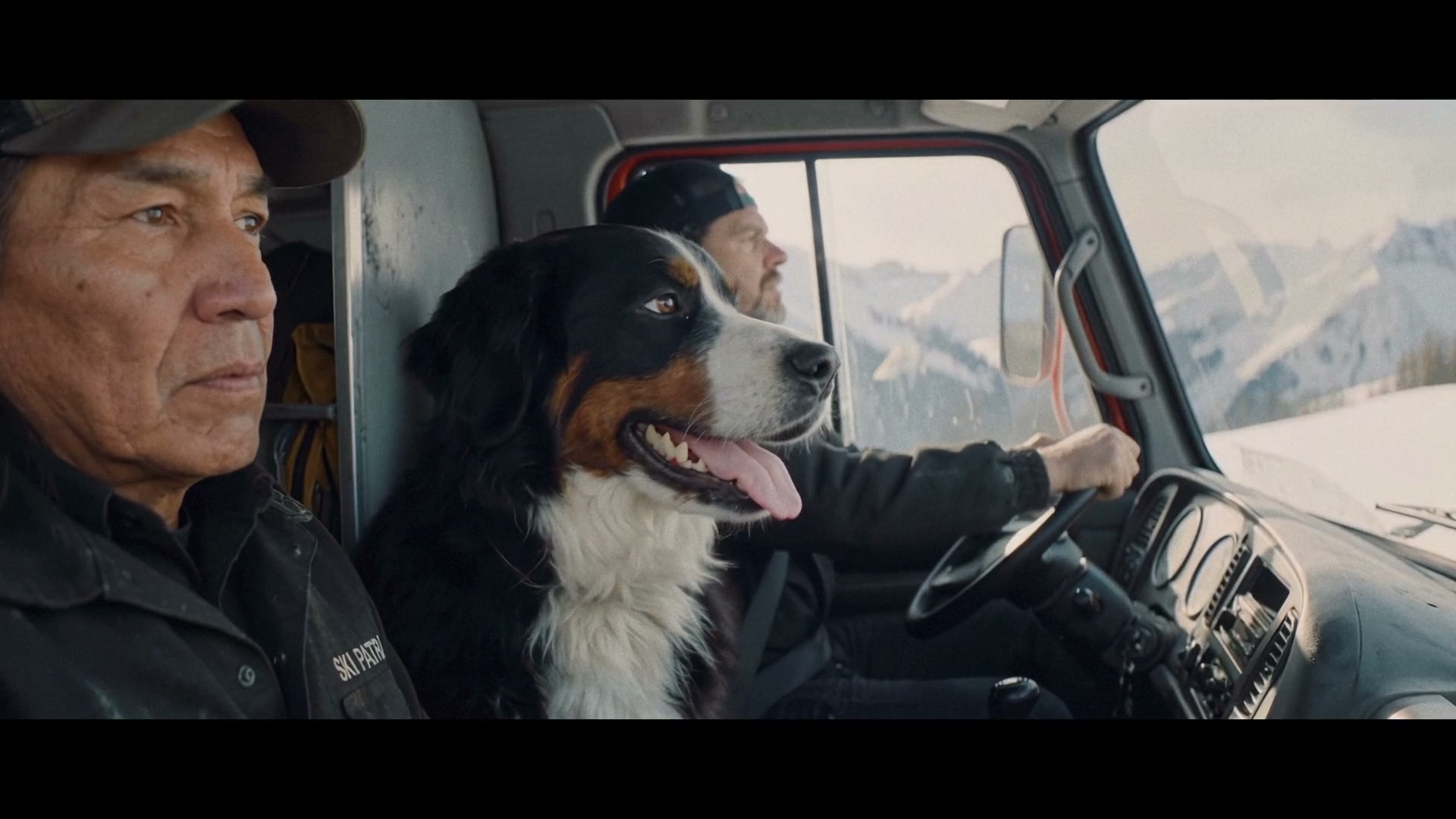 Three rescue workers and a Bernese mountain dog riding inside a snowcat in Adrenaline Junkies