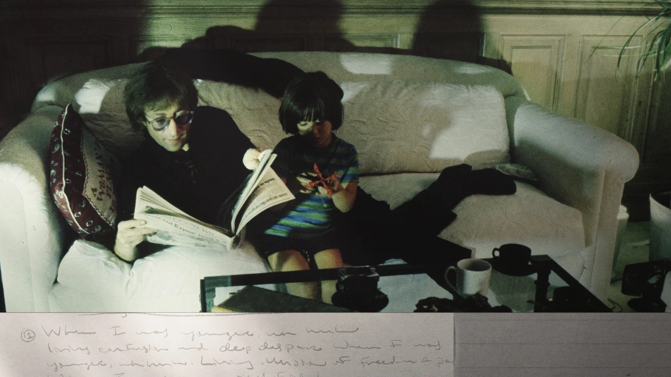 John Lennon reading with a child in a still from John Lennon: The Last Interview