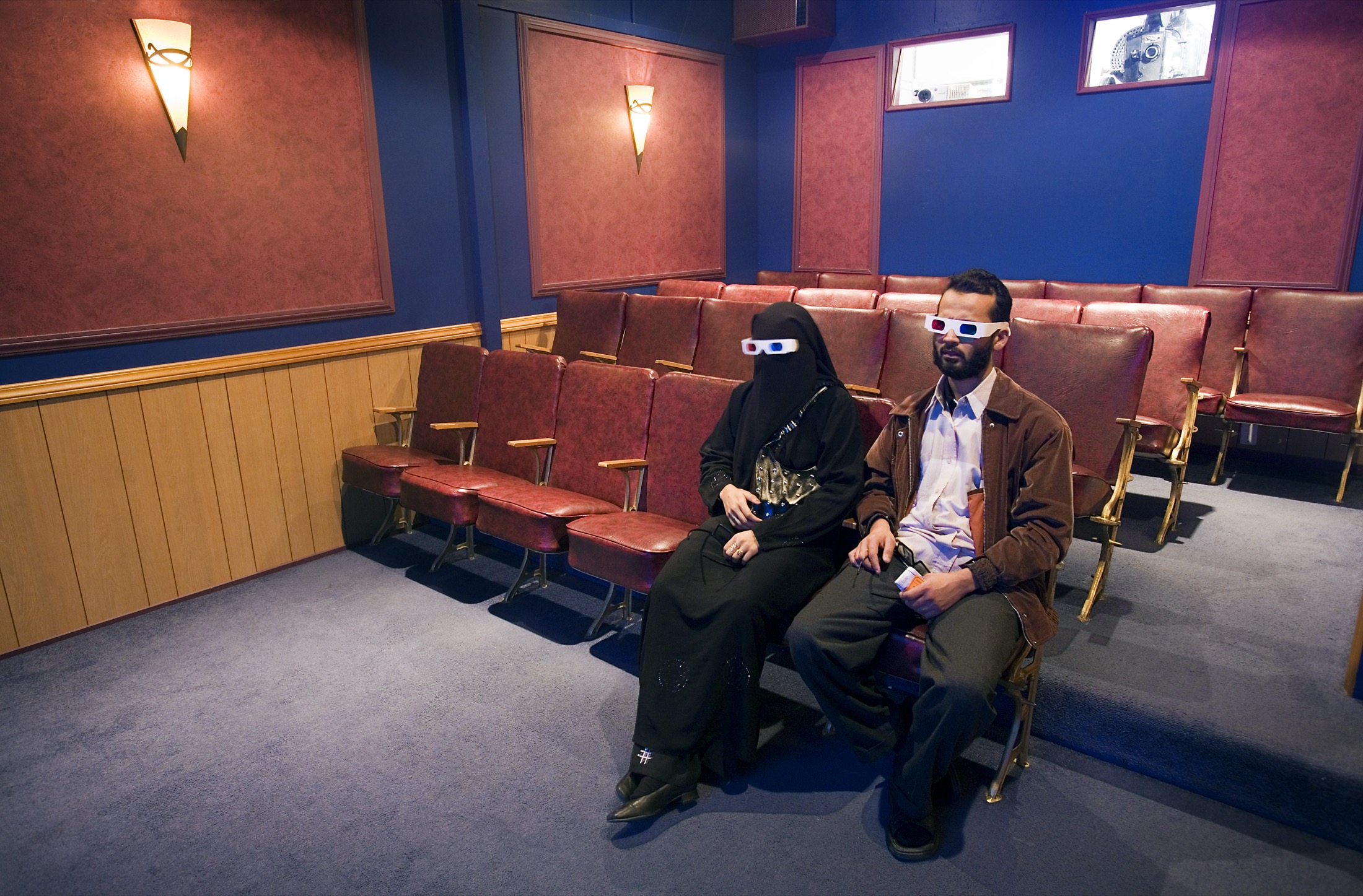 Two people wearing 3D glasses in a private cinema screening room