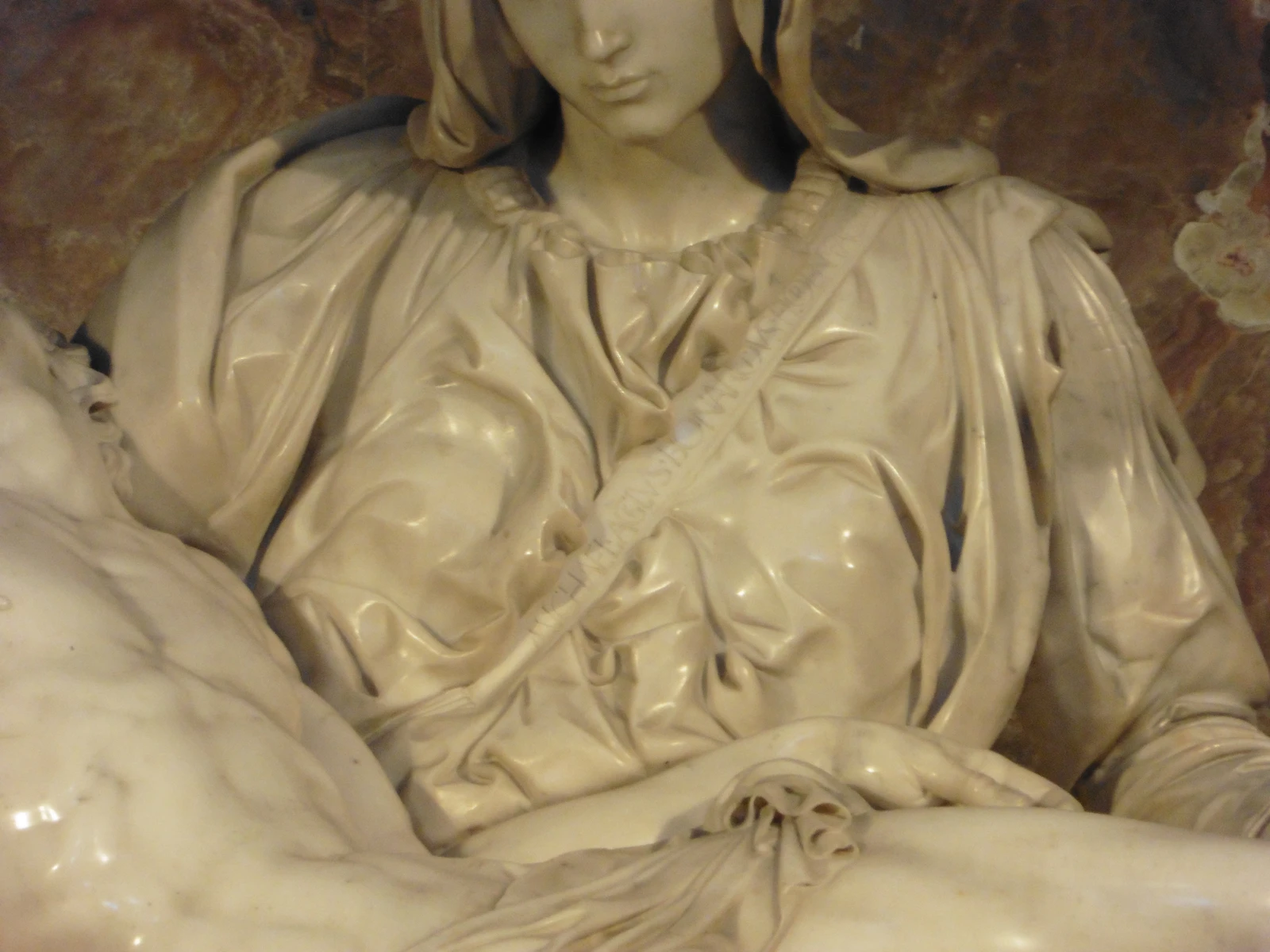 Close-up of Michelangelo’s signature carved into the diagonal sash across Mary’s chest
